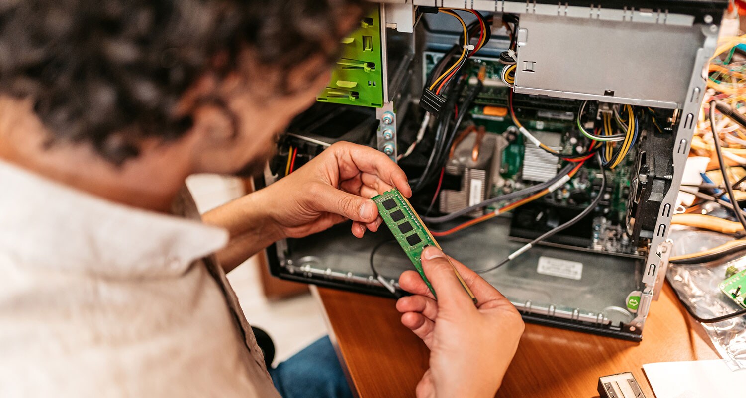 A man holding a stick of memory after learning how to free up RAM and install more.