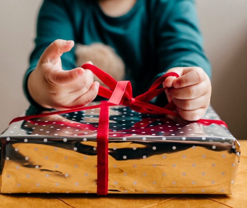 An image of a person wrapping a Christmas present.