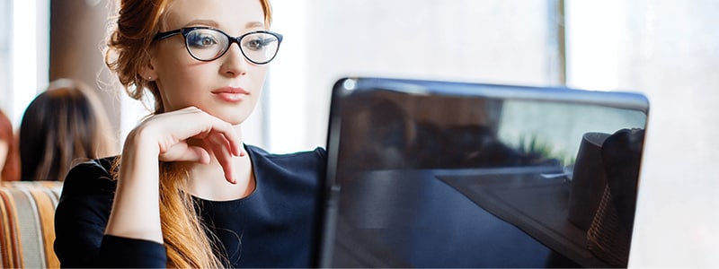 A woman on her computer navigating how to delete the cookies on her device.