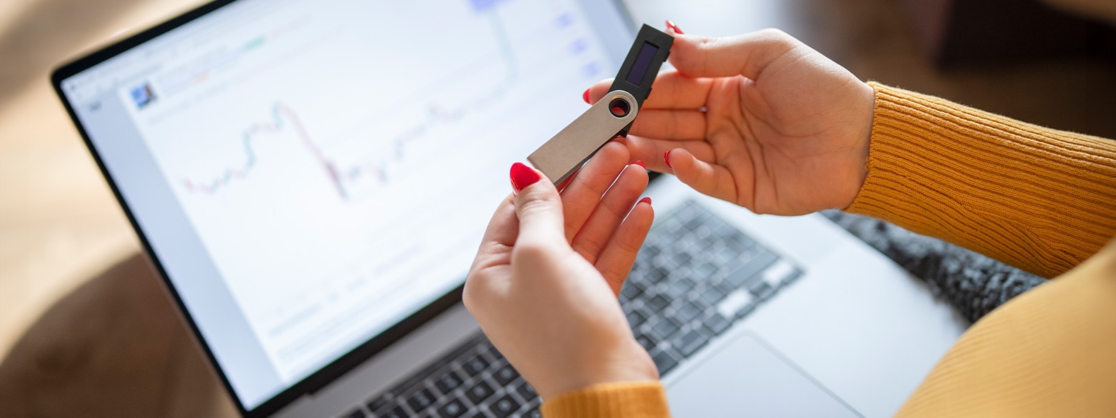 A woman opens a flash drive before plugging it into a laptop.