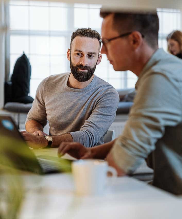 Two men sit at a computer reviewing the cryptography algorithm they want to use for their new secure messaging app.