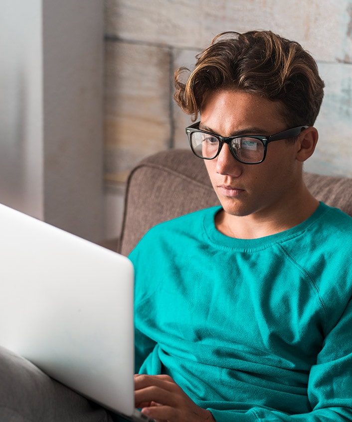 A man uses his laptop to research what a script kiddie is.